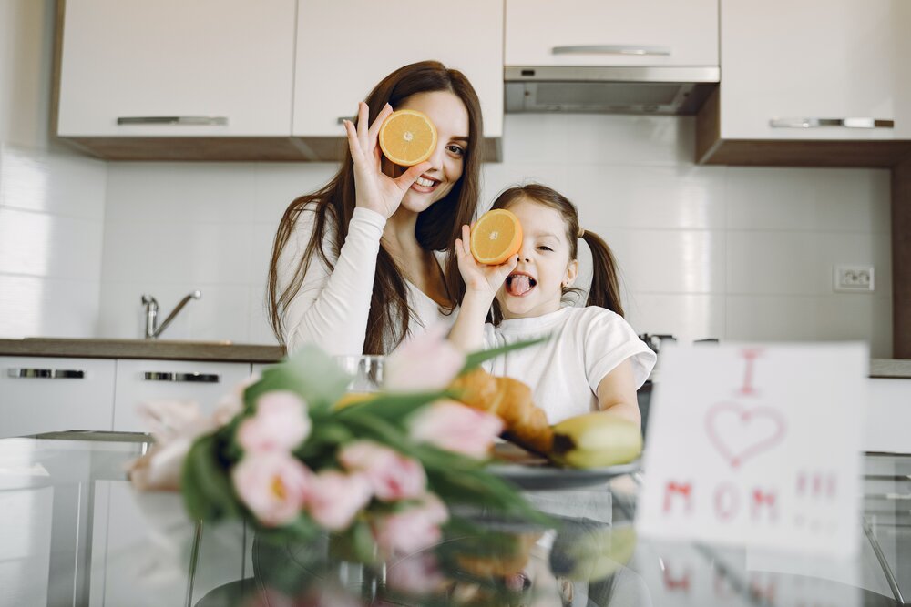 delighted-mother-and-daughter-eating-oranges-in-kitchen-4149010.jpg