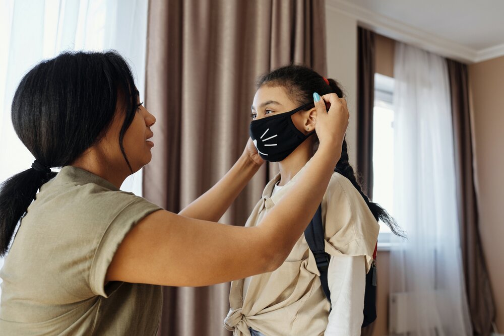mother-putting-a-face-mask-on-her-daughter-4261252.jpg